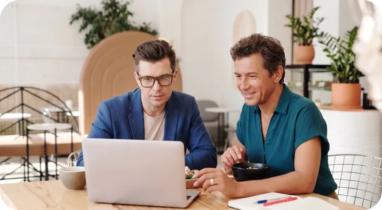 Two professionals reviewing the ETSI TS 119 461 identity verification standard on a laptop.