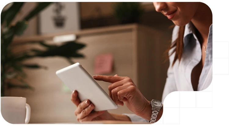 Young woman holding a tablet while signing digitally.