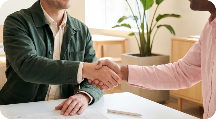 Hombre  y mujer estrechando la mano tras firmar un acuerdo de confidencialidad.