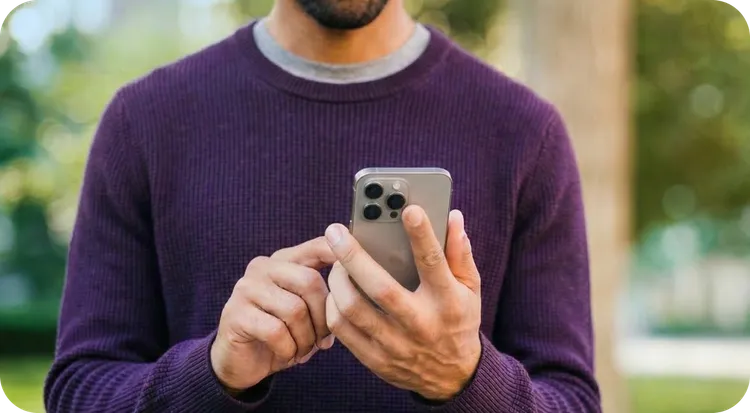 Hombre joven leyendo con atención una notificación fehaciente recibida en su teléfono móvil.