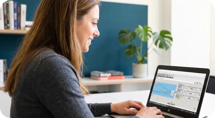 Mujer sonriente trabajando en un portátil con un software de automatización inteligente.