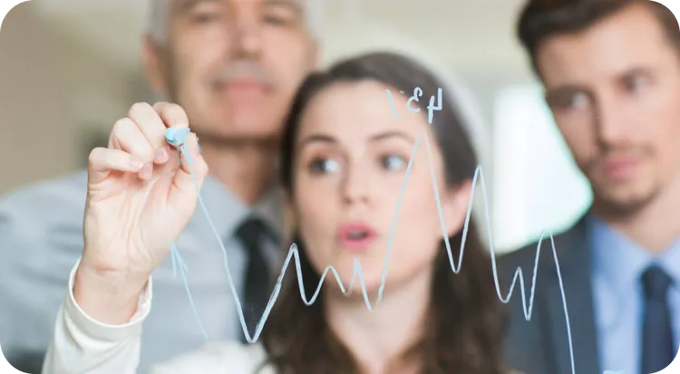Equipo de profesionales analizando tendencias de ventas en una pizarra.