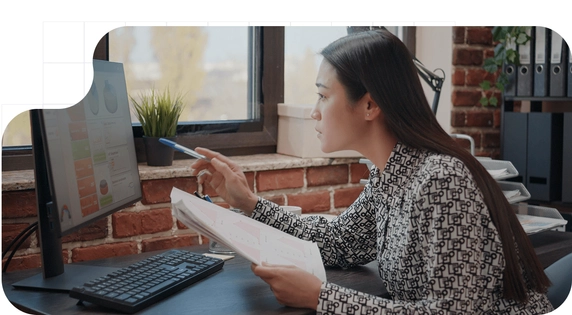 Profesional analizando datos financieros en su monitor preparándose para gestionar la factura electrónica.