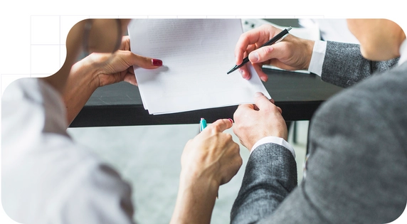 Personas revisando y señalando un documento físico para agilizar la firma manuscrita del mandato SEPA.
