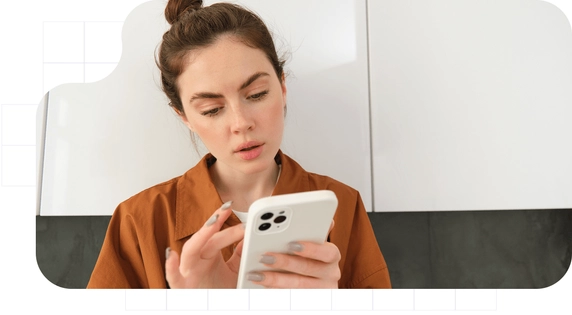 Mujer joven leyendo con atención una notificación fehaciente recibida en su teléfono móvil.