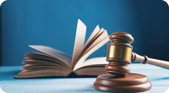 Judge's gavel and open law book on a blue background.