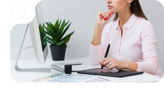 Woman working on digital design with a graphic tablet in front of a computer.