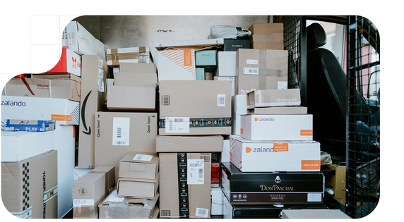 Furgoneta de reparto estacionada con la puerta trasera abierta, mostrando el interior lleno de cajas apiladas.