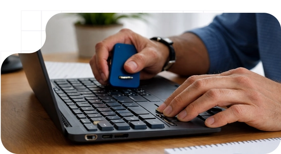 A person connecting a USB security device to a laptop to manage the digital signature.