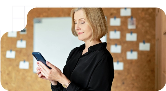 Woman using a mobile phone in a professional environment, consulting digital information