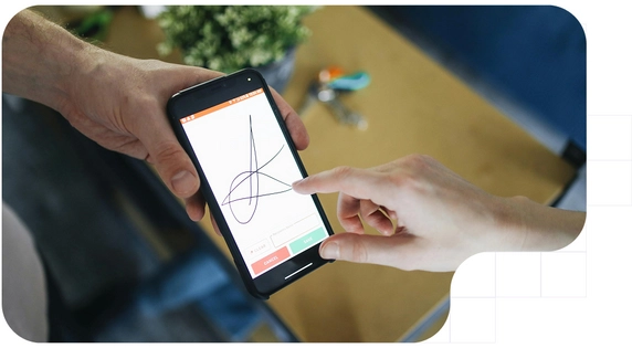 Persona firmando digitalmente en la pantalla de un teléfono móvil sostenido con ambas manos.