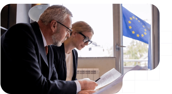 Experts analyzing DAC7 regulatory documents for digital platforms, with the EU flag in the background.